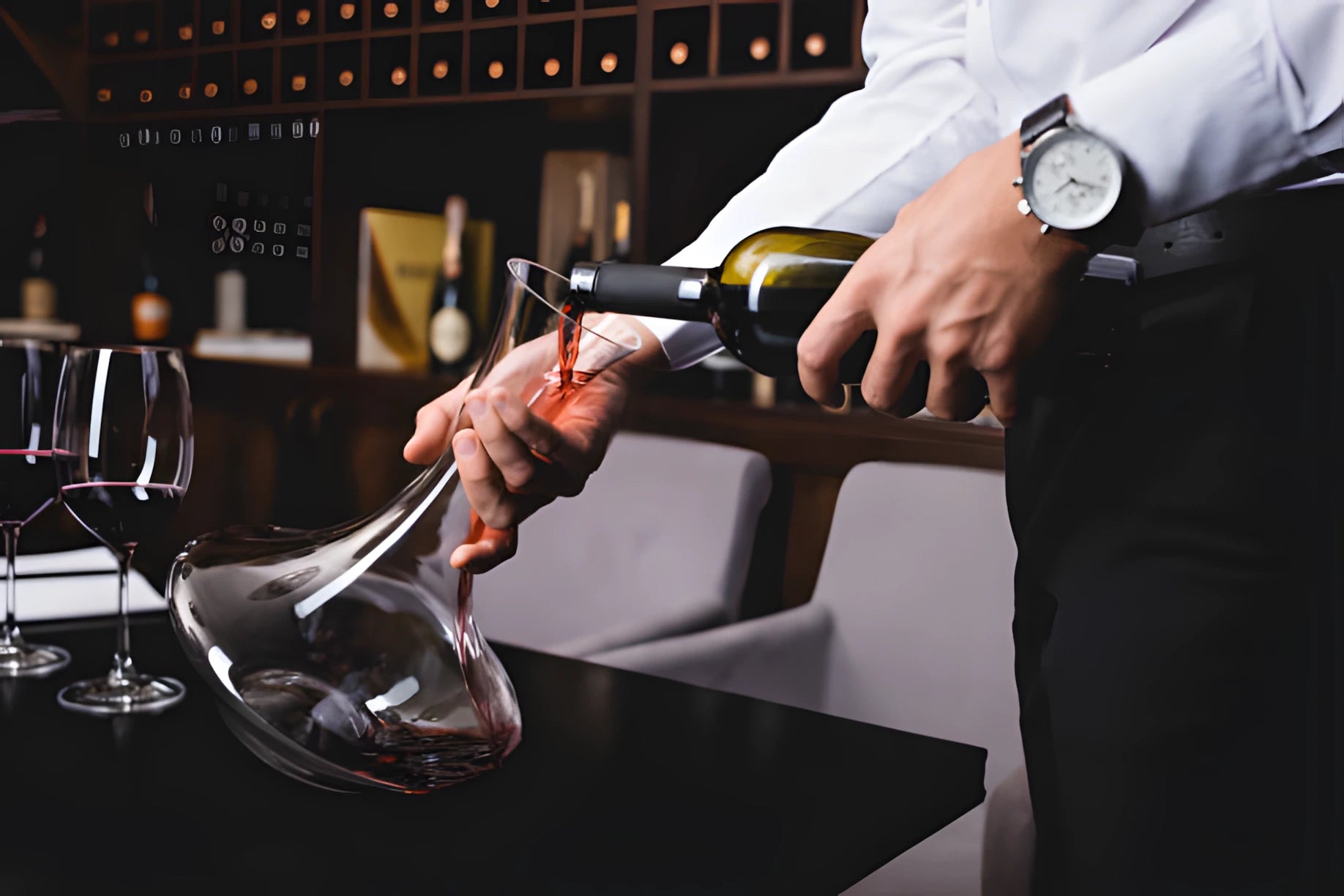 Carafe à décanter posée sur une table dressée avec un verre de vin rouge