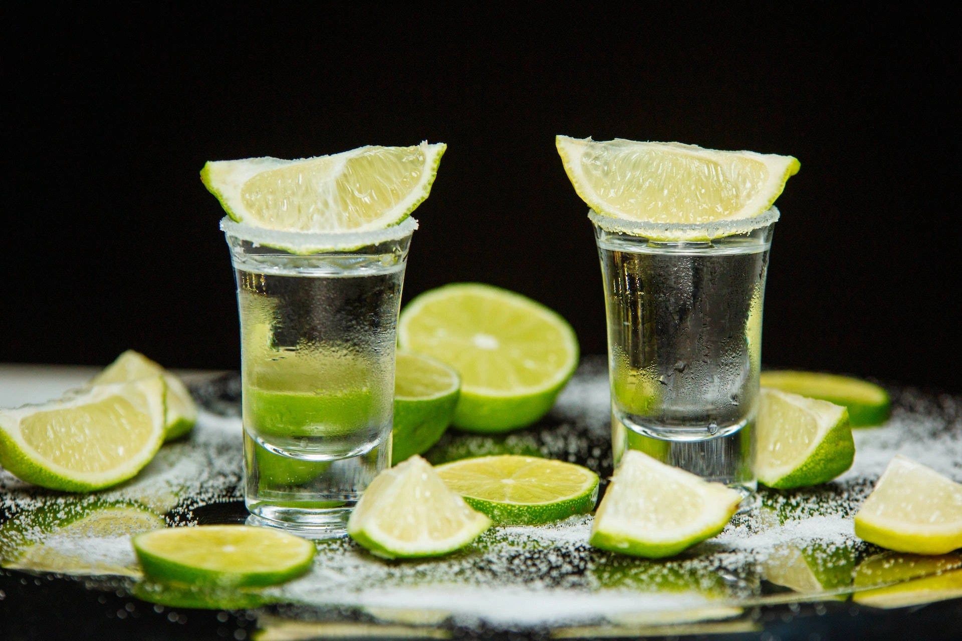 Bouteilles de tequila et verre de dégustation sur un bar élégant, éclairage ambré