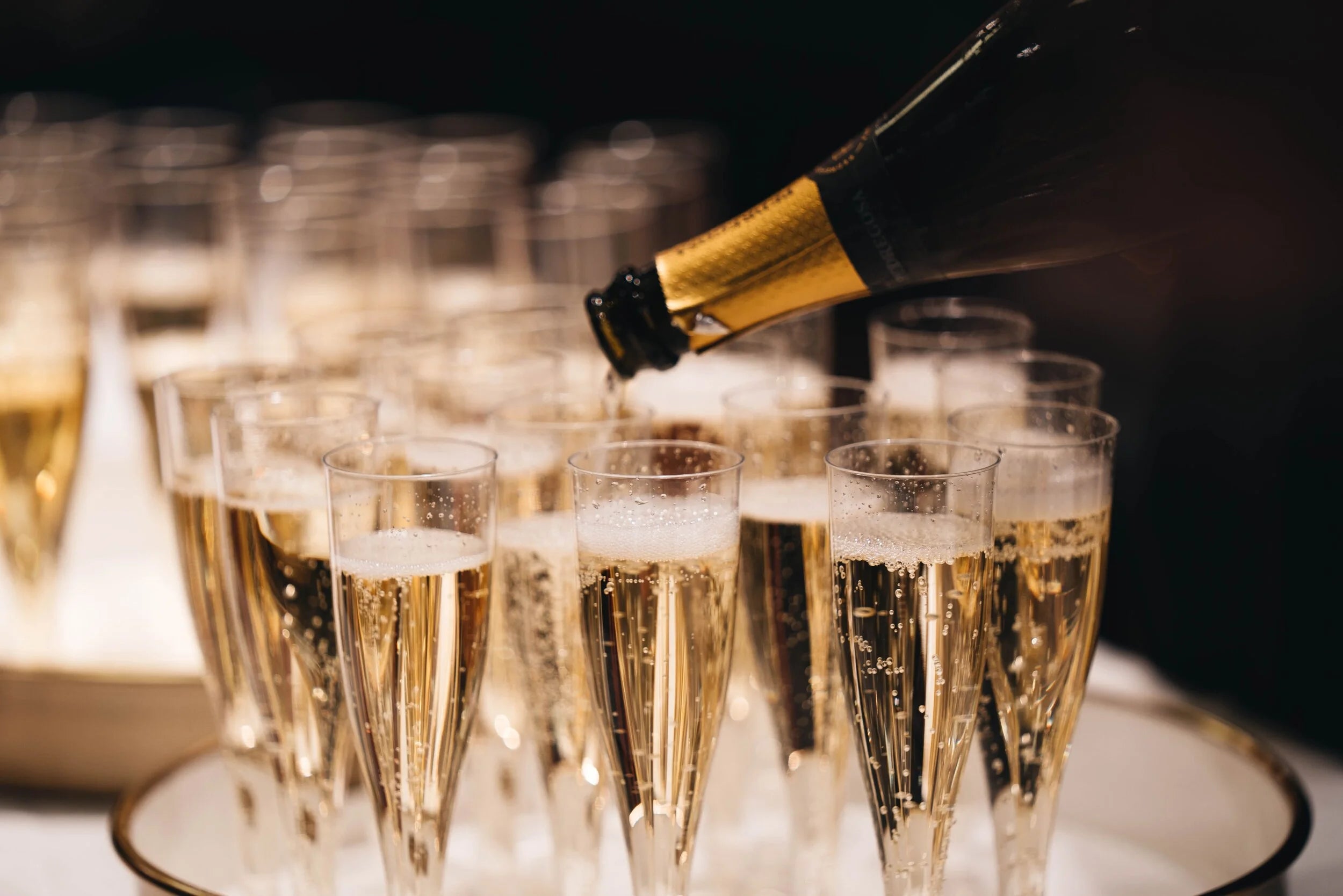 Flûte à champagne élégante sur table dressée, lumière dorée et bulles fines