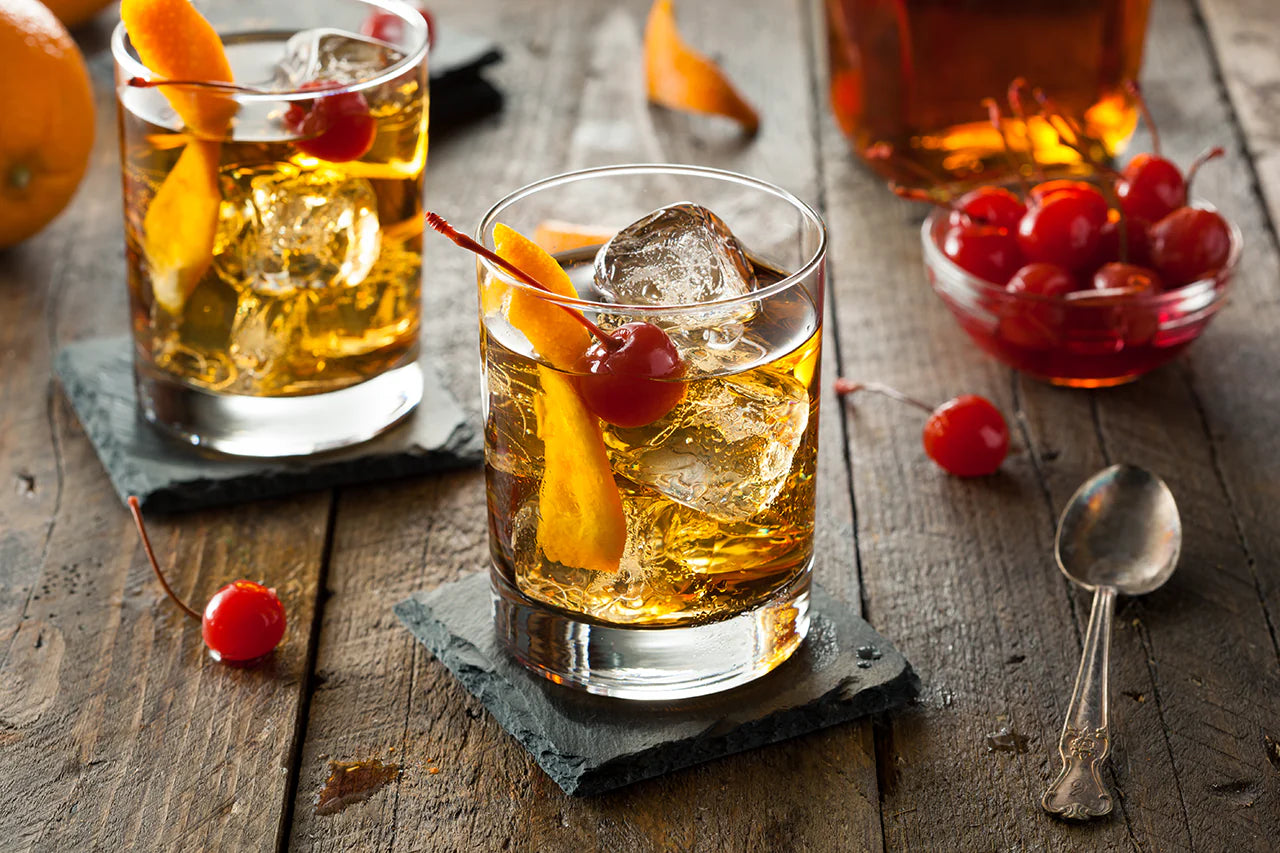 Old Fashioned cocktail au whisky avec gros glaçon et zeste d'orange